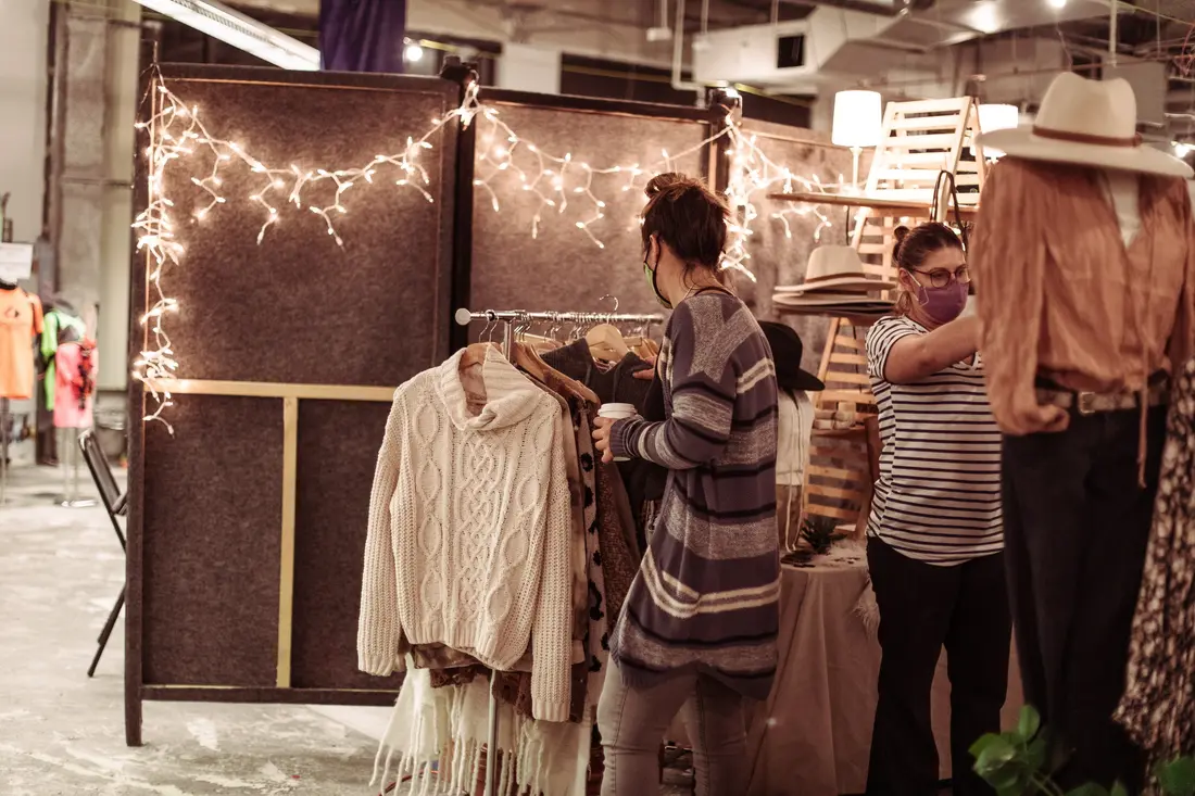 Racks of clothing and shoppers at the Belmar Holiday BAZAAR.