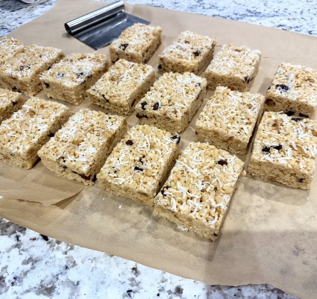 Crispy rice bars cut into squares on parchment.