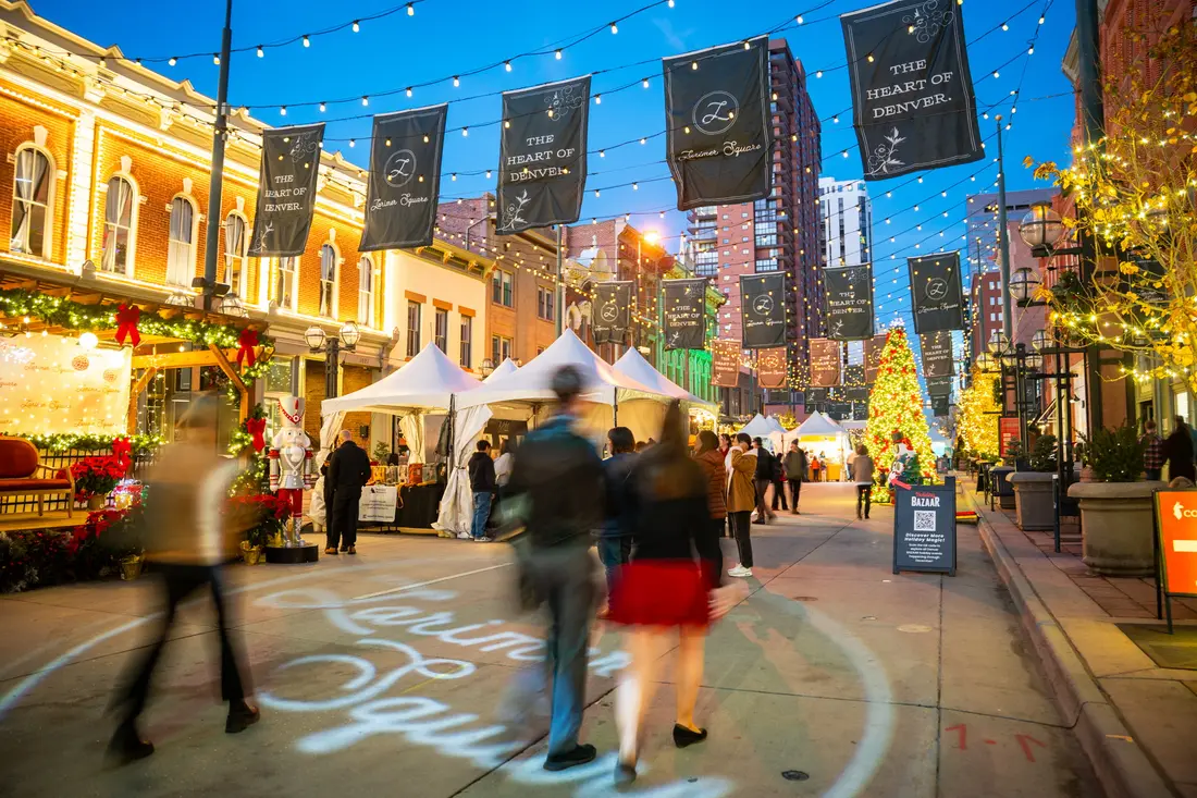 Larimer Square at dusk on a market Saturday: banners and string lights over the block, tents down the middle.