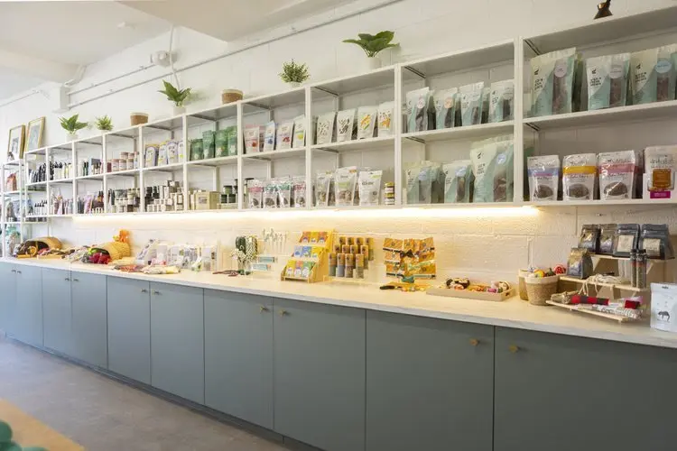 A long white shop counter and shelves of packaged pet goods.