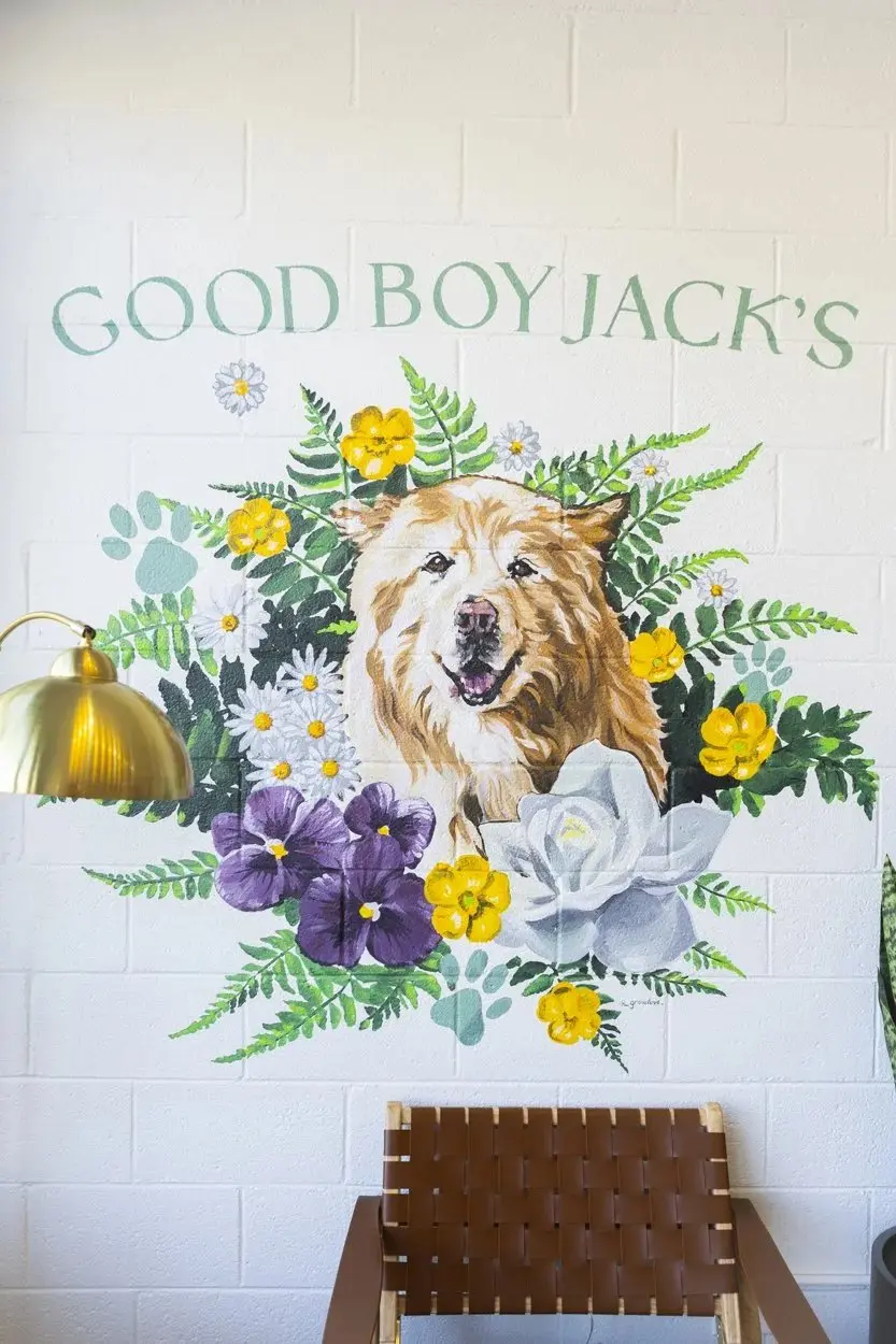 A painted mural of a golden dog among flowers with the words Good Boy Jacks.