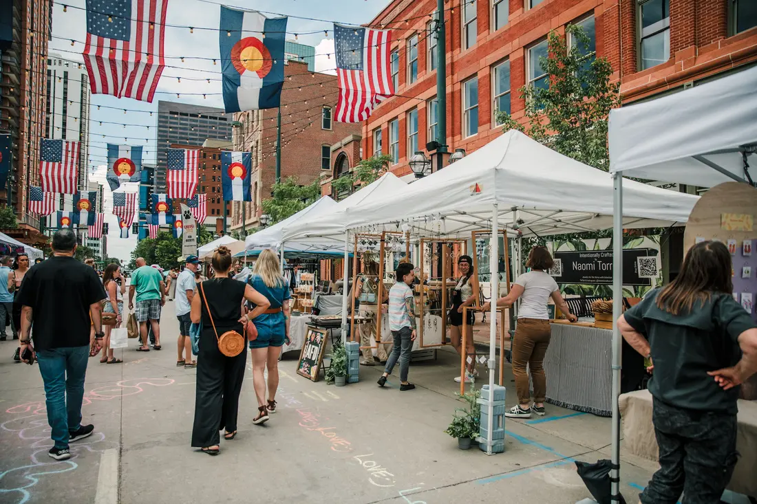 Larimer Square on a market Saturday, tents down the block under the flag canopy.