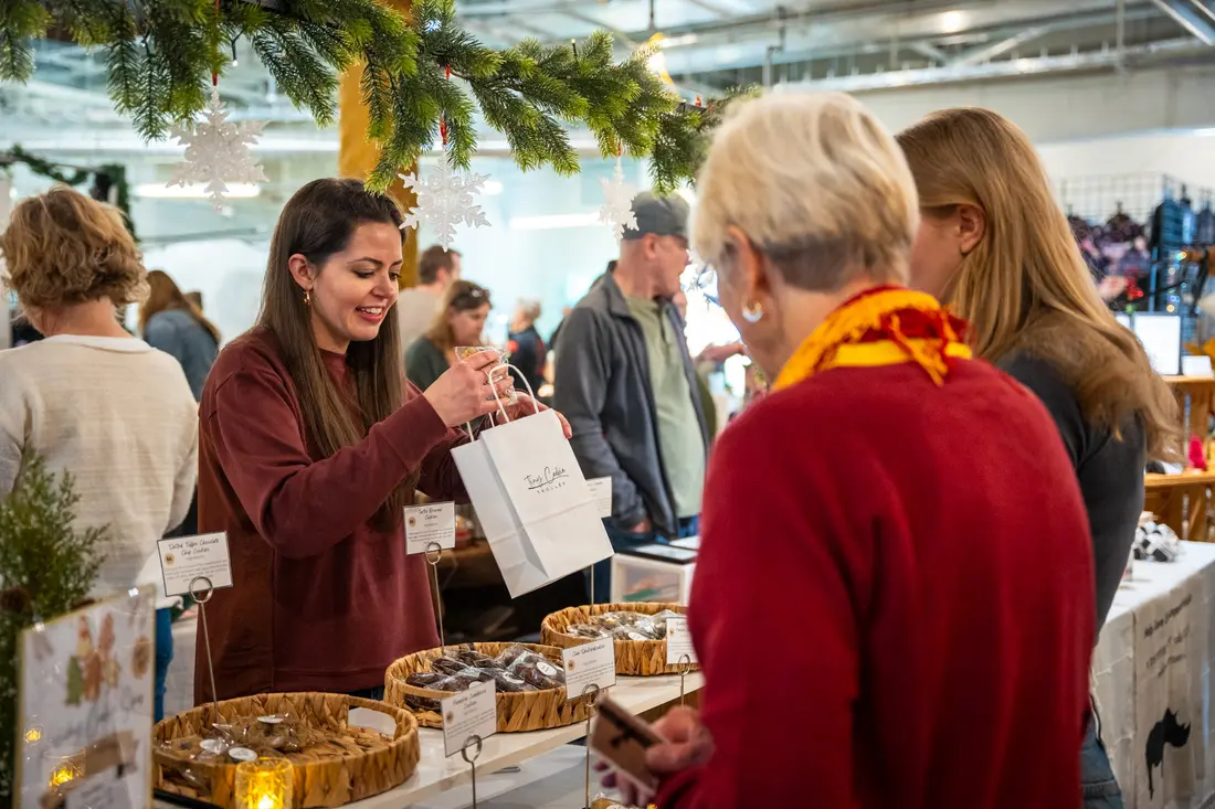 The crowd shoulder to shoulder between booths at the Downtown Lakewood Holiday BAZAAR.