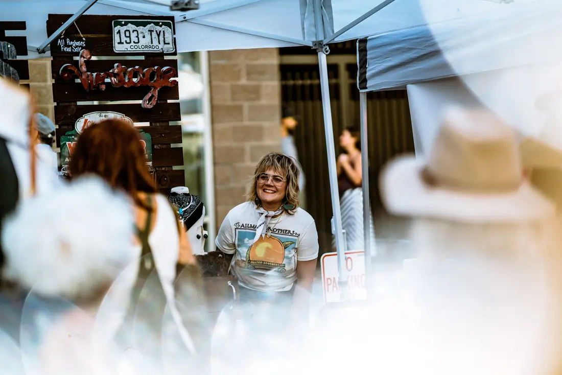 A maker at her table at a Fall BAZAAR in 2019, bottles and jars laid out in front of her.