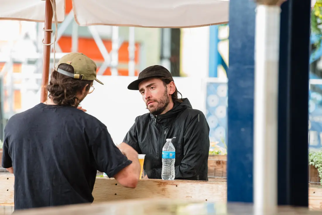 Two people talking across a maker’s table at the Belleview Station Fall BAZAAR.