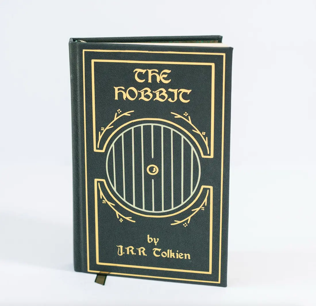 A green leather-bound copy of The Hobbit with a round door tooled in gold on the cover.