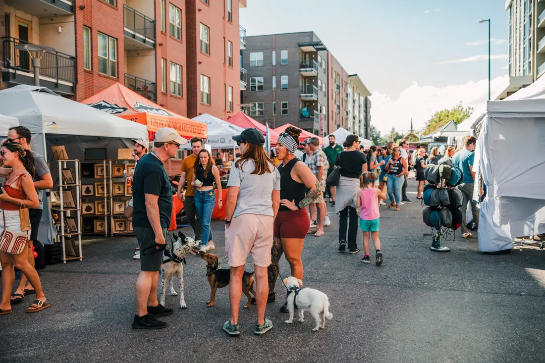 The street at Sloan’s Lake lined with white tents and the Saturday crowd, a small dog in the middle of it.